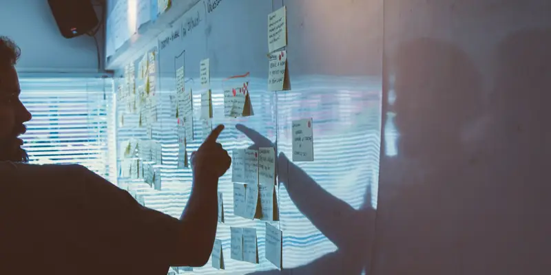 Consultant mapping an AI strategy on a wall of notes