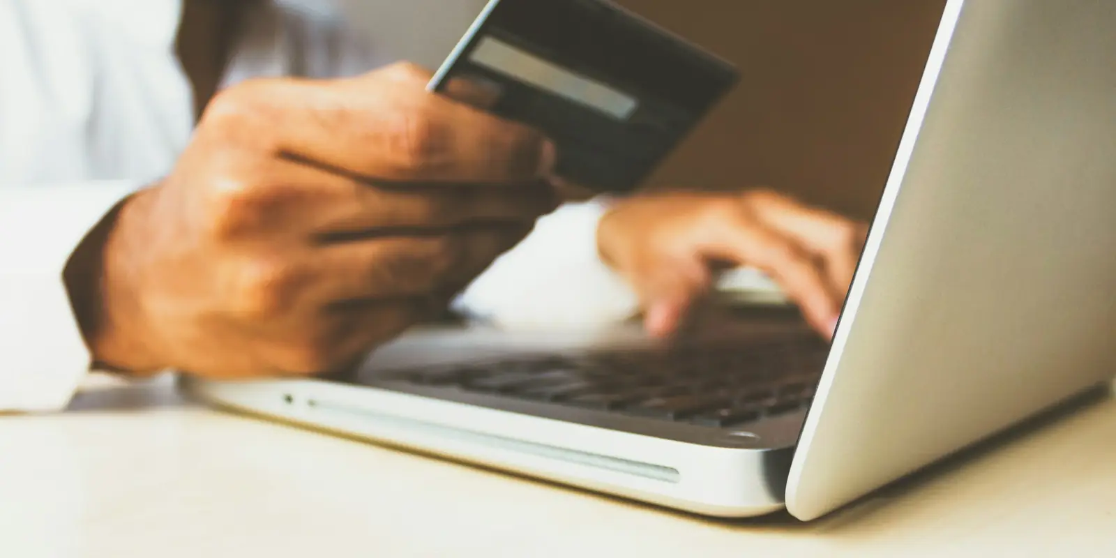 Shopper paying online with a card on a laptop