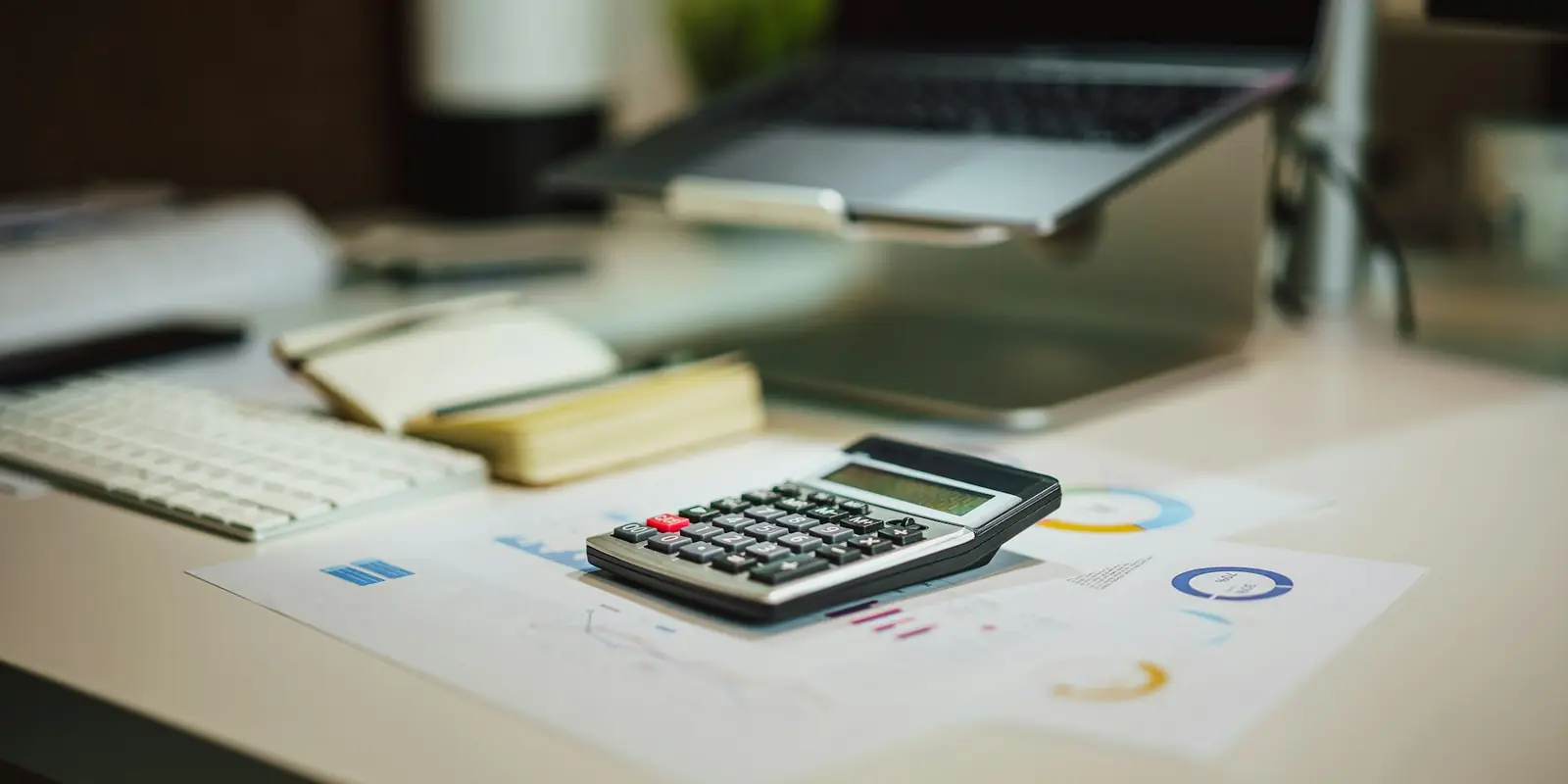 Accountant's desk with a calculator and financial reports: Lead Generation