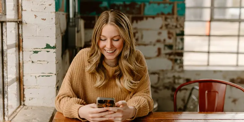 Woman browsing social media on her phone in a cafe